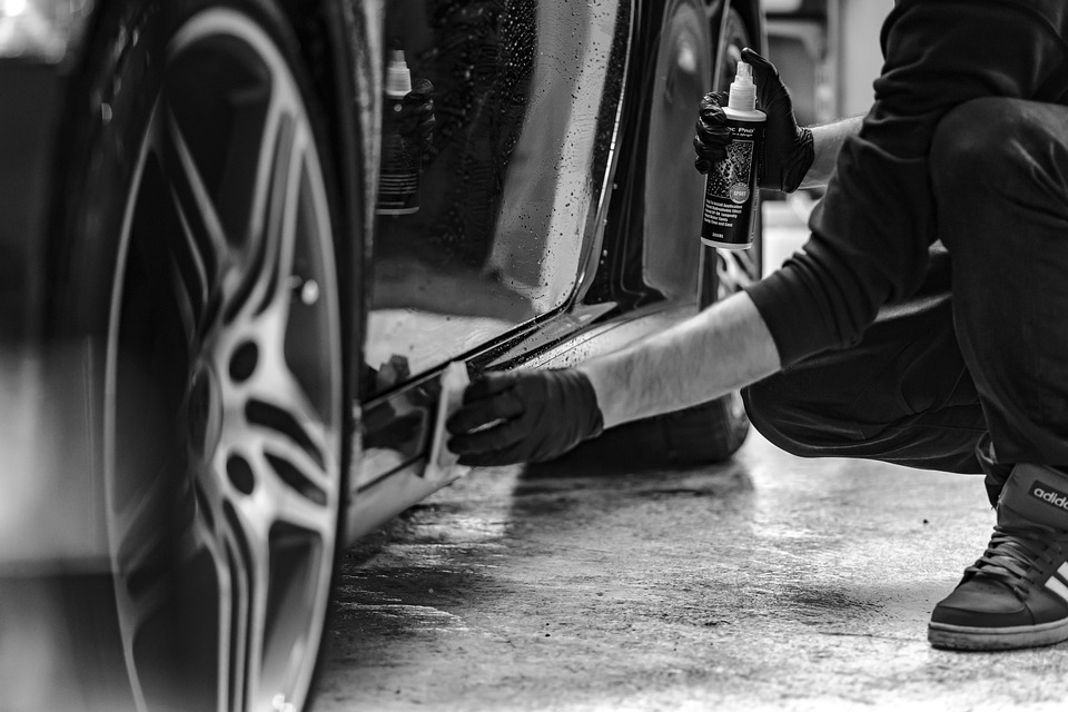 Detailer bei der sorgfältigen Reinigung eines Fahrzeugbereichs